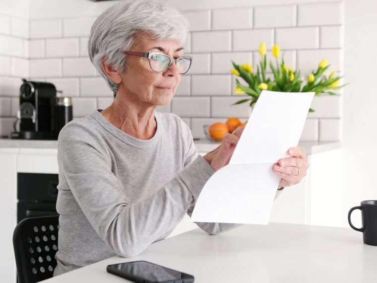 Middle Aged Woman Reading Financial Letter Document Attentively