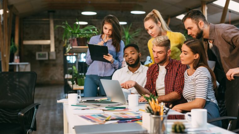 Agency coworkers discussing new project on laptop