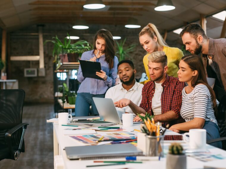 Agency coworkers discussing new project on laptop